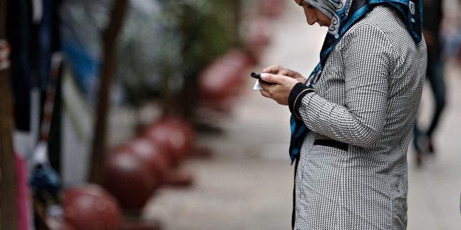 En 2015, la crise migratoire révélait le lien entre migrants et numérique. Ici, en septembre 2015, une réfugiée regardait son téléphone au square Victoria, à Athènes, où les migrants restaient temporairement. Photo : Alexandros Michailidis.